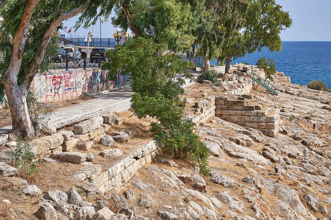 Ancient masonry beside the rocky coast and a modern walkway at Piraeus